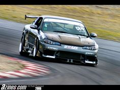 a car driving on a race track with grass in the background