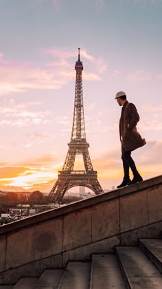 a man standing on top of steps near the eiffel tower