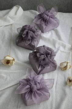 four pieces of fabric with flowers attached to them on a white sheeted bed spread