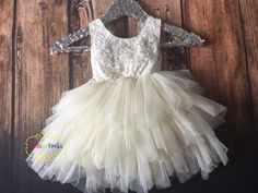 This chic dress is perfect for your princess. My brand for this dress is Fairy Godmother. It comes with a beautiful white lace bodice and a ivory tulle tutu knee length skirt with just the right amount of fluffy.  Complimented with an intricate lace applique on the front.  The V-neck design with unfinished lace on the back adds even more charm and character.  Your princess will stand out even more at her next special event.  All sales are final. No Returns No Exchange. Perfect for: Flower Girl Dress, Birthday party, Cake Smash, Photography Prop, Bridesmaid dress,  Wedding dress, Paired with Cowboy boots. I recommend the dress be steam cleaned. Due to different fabric batches used in making the dress, the color may vary slightly from the photo.  Feedback: If there is any issue with the dres Cream Tutu Dress With Ruffles For Baptism, Cream Ruffled Tutu Dress For Baptism, Cream Princess Dress For Dress-up, Cream Princess Dress With Ruffles, Cream Princess Tutu Dress For First Communion, Cream Tutu Dress For Pageant, Cream Princess Style Sleeveless Baptism Dress, Sleeveless Cream Princess Dress For Pageants, Cream Sleeveless Princess Tutu Dress