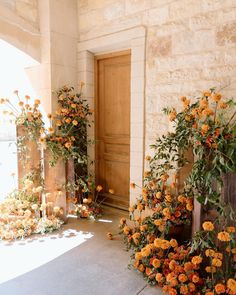 orange flowers are growing on the side of a building