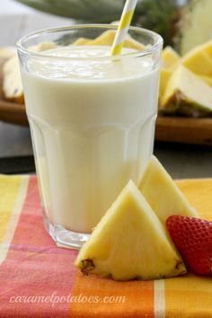 there is a glass of milk and some fruit on the table