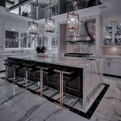 a large kitchen with marble counter tops and gold accents