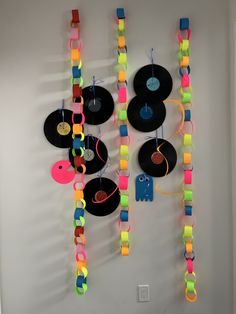 there is a wall decoration made out of vinyl records and colorful streamers attached to the wall