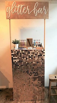 a wooden sign sitting on top of a counter next to a chair and table with bottles