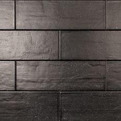 a close up view of a black tile wall