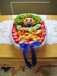 a basket filled with lots of different types of fruit on top of a wooden table