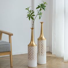 two vases with plants in them sitting on the floor