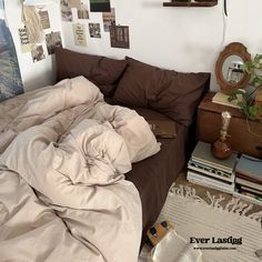 an unmade bed in a bedroom with many pictures on the wall