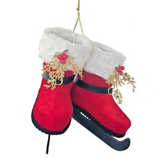 a pair of red snow boots hanging from a string on a white background with gold trimmings