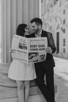 a man and woman are holding up a newspaper