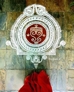 a red cloth sitting on top of a tile floor next to a wall with a white design