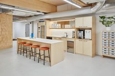 a kitchen with an island and stools next to it in the middle of a room