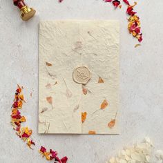 a piece of paper sitting on top of a table next to flowers and a bell