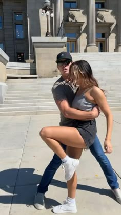 a man and woman dancing in front of a building