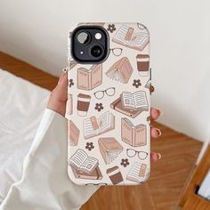 a person holding up a phone case with books and glasses on it