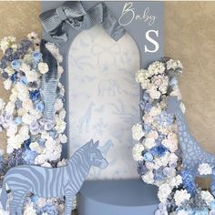 a baby's room with blue and white flowers, giraffes and zebra