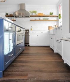 a kitchen with wood floors and white cabinets