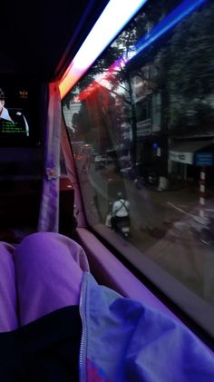 a person sitting in the back seat of a car watching tv on their cell phone