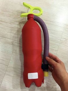 a hand is holding a red fire extinguisher