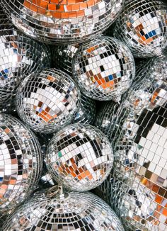 many disco balls are stacked on top of each other with mirrors reflecting them in them