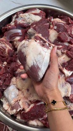 a person is holding some meat in a bowl