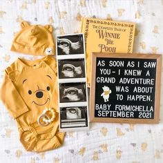 a winnie the pooh baby gift set next to its parent's handwritten sign