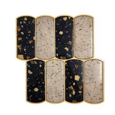 six pieces of black and white marble with gold accents on each side, set against a white background