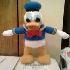 a crocheted donald ducky doll is posed