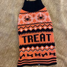 an orange and black dog sweater with the word treat on it