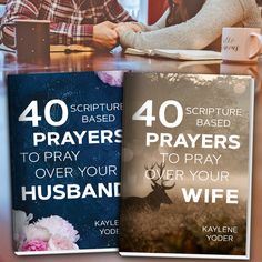 two book covers sitting on top of a table next to coffee mugs and flowers