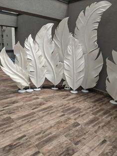 several white feathers are lined up against a wall in an office building or waiting area