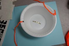 a white paper plate with an orange string attached to it