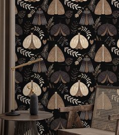 a chair and table in front of a black wallpaper with gold leaves on it