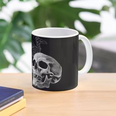 a black and white coffee mug with a skull on it