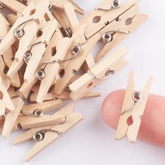 small wooden clothes pins are being held by a hand