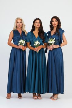 three bridesmaids in blue dresses posing for the camera