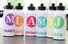 four personalized water bottles sitting on top of a table