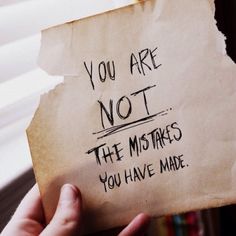 someone holding up a piece of paper that says you are not the mistakes you have made