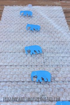 four blue elephants are on the ground and one elephant is in the middle of it