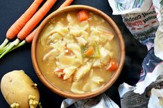 a bowl of soup with carrots and celery next to it