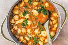 a pot filled with pasta and spinach soup