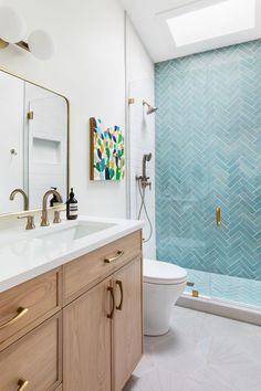 a bathroom with blue and white tiles on the walls, wood cabinets, and a toilet