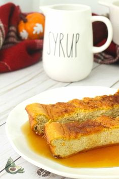 two slices of cake on a plate with caramel syrup and pumpkins in the background