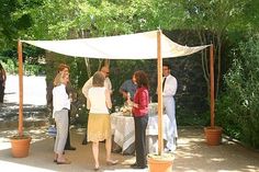 a group of people standing around a table under a canopy