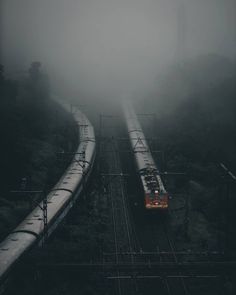 a train traveling down tracks in the fog