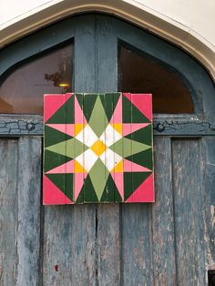 a wooden door with a pink and green star on it