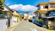 an empty street lined with houses on both sides and a bike leaning against the fence