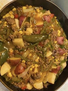 a skillet filled with meat and vegetables on top of a stove burner oven