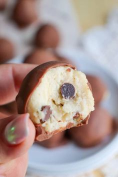 a hand holding a half eaten chocolate covered cookie